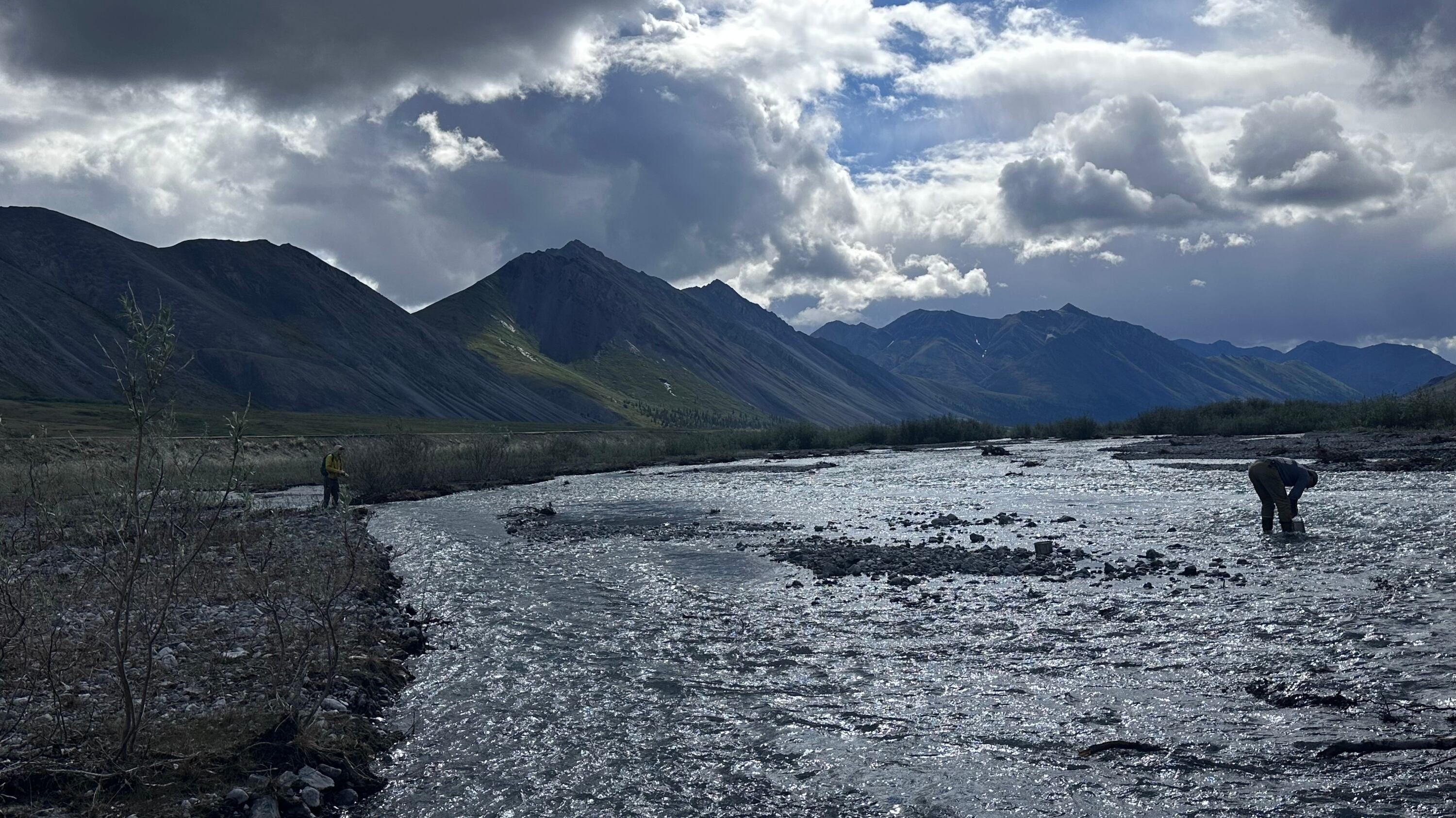 While journalist Chris D'Angelo casts his fly rod after the day’s first meal, tour guide “Country” does some dishes in a creek in the Arctic National Wildlife Refuge in Alaska on July 1.