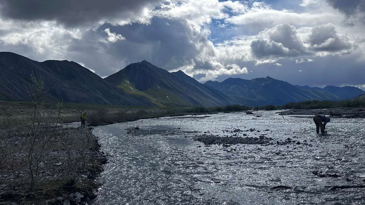 While journalist Chris D'Angelo casts his fly rod after the day’s first meal, tour guide “Country” does some dishes in a creek in the Arctic National Wildlife Refuge in Alaska on July 1.