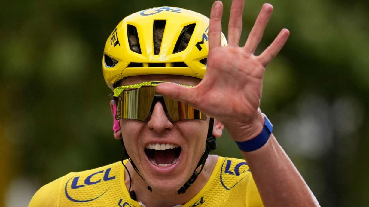 Slovenia's Tadej Pogacar, wearing the overall leader's yellow jersey, celebrates as he crosses the finish line of the last stage of the Tour de France cycling race with start and finish in Paris, Sunday, July 26, 2026.