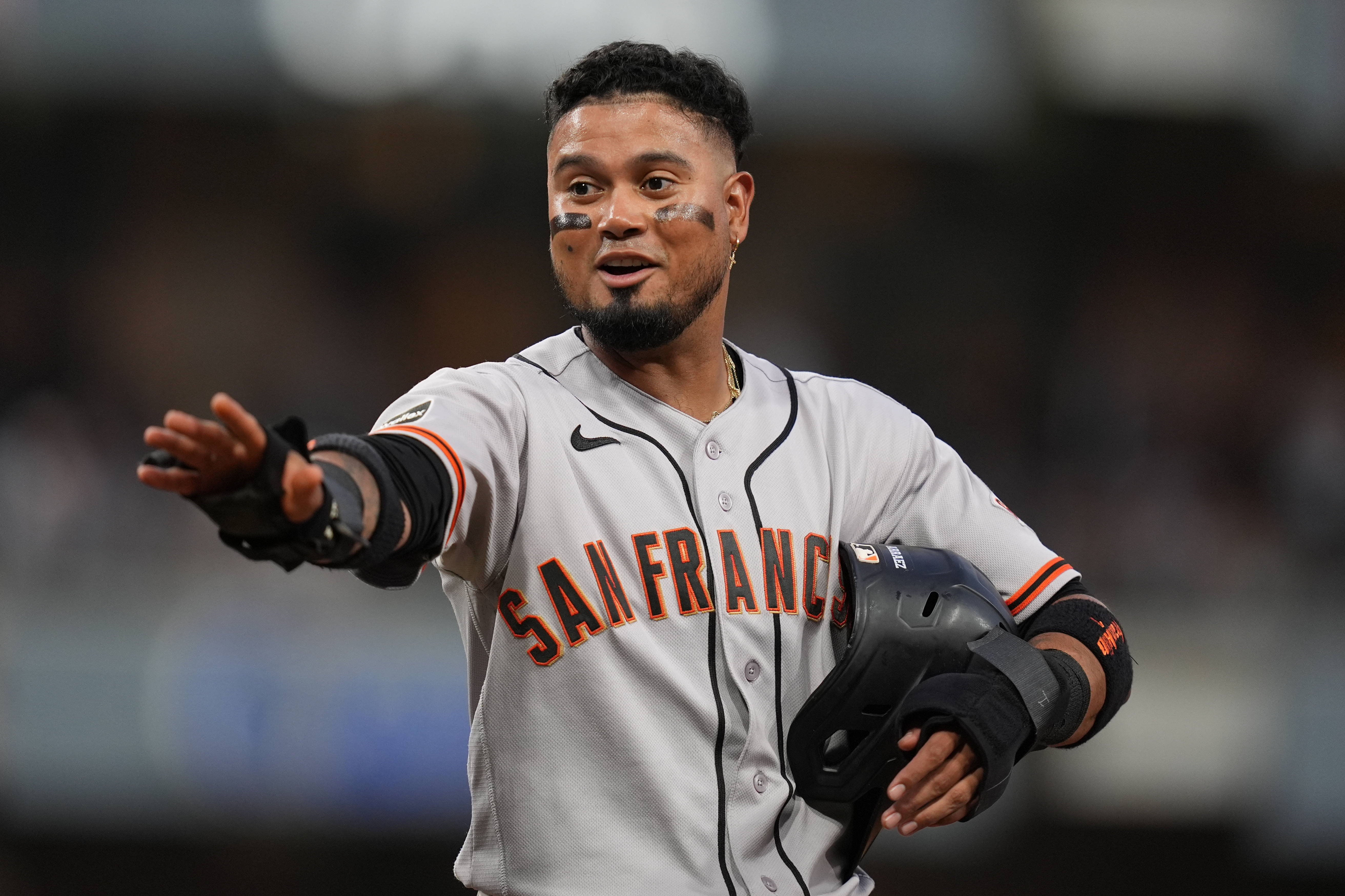 San Francisco Giants' Luis Arraez jokes with players in the San Diego Padres dugout as he stands on first base after getting hit by a pitch during the fourth inning of a baseball game Thursday, July 30, 2026, in San Diego. 
