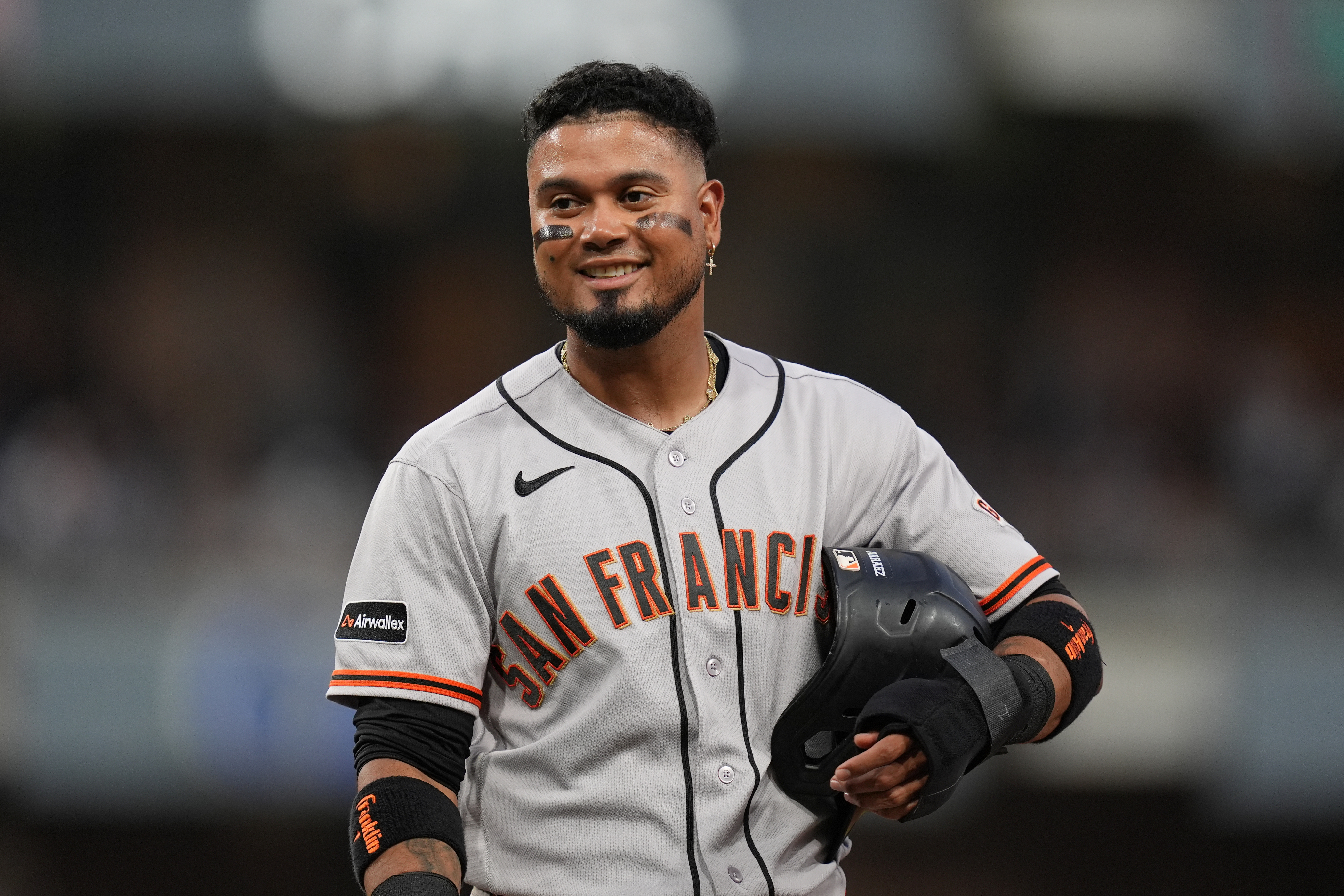 San Francisco Giants' Luis Arraez jokes with players in the San Diego Padres dugout as he stands on first base after getting hit by a pitch during the fourth inning of a baseball game Thursday, July 30, 2026, in San Diego. 