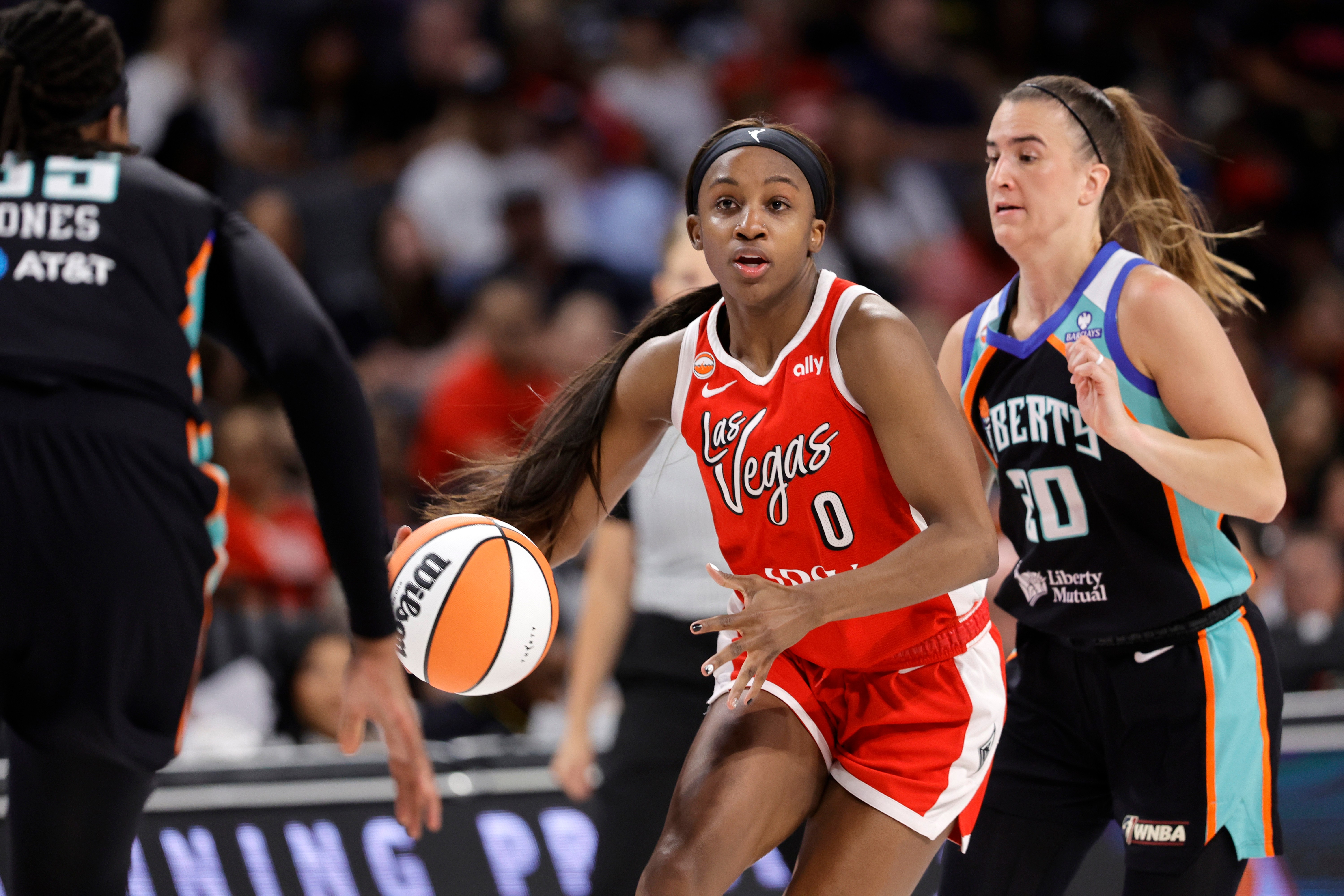 Las Vegas Aces guard Jackie Young (0) drives between New York Liberty center Jonquel Jones, left, and guard Sabrina Ionescu (20) during the first half of an WNBA basketball game Thursday, July 30, 2026, in Las Vegas. 