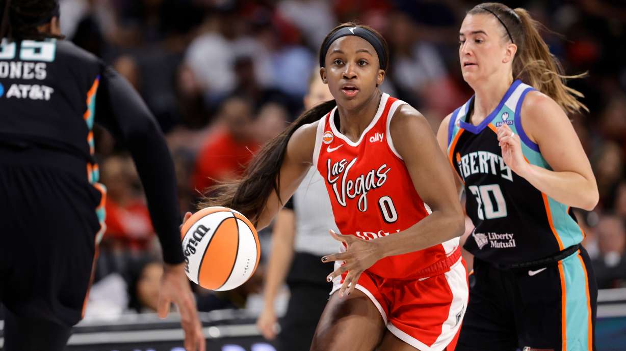 Las Vegas Aces guard Jackie Young (0) drives between New York Liberty center Jonquel Jones, left, and guard Sabrina Ionescu (20) during the first half of an WNBA basketball game Thursday, July 30, 2026, in Las Vegas.