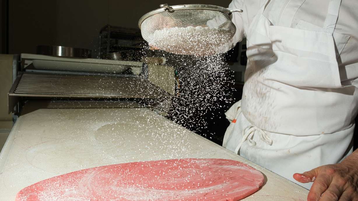 Chris Hereghty, Executive Pastry Chef of Sant Ambroeus rolls out a sheet of marzipan.