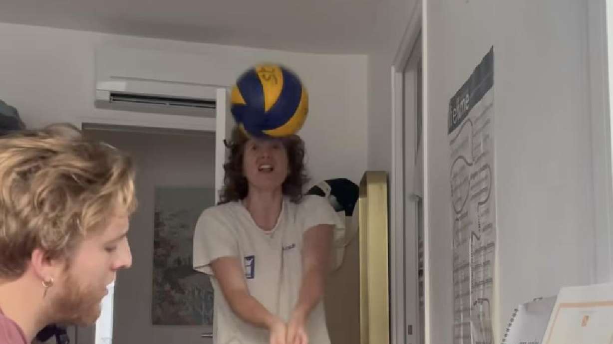 A woman plays volleyball while singing a Dolly Parton song.