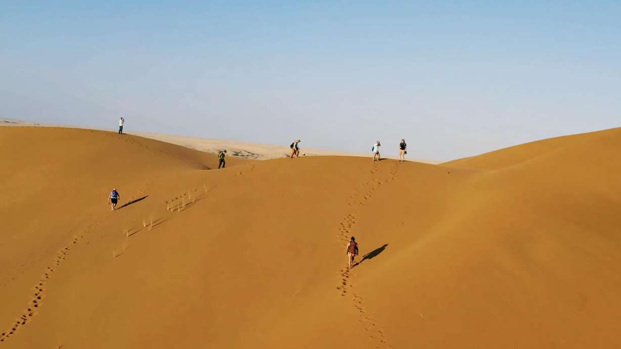 BYU researchers on a sand dune in Namibia, Africa. NASA has called on a group of them to help develop an understanding of the landscape that its Dragonfly rotorcraft will be exploring on its voyage to Titan, Saturn's largest moon.