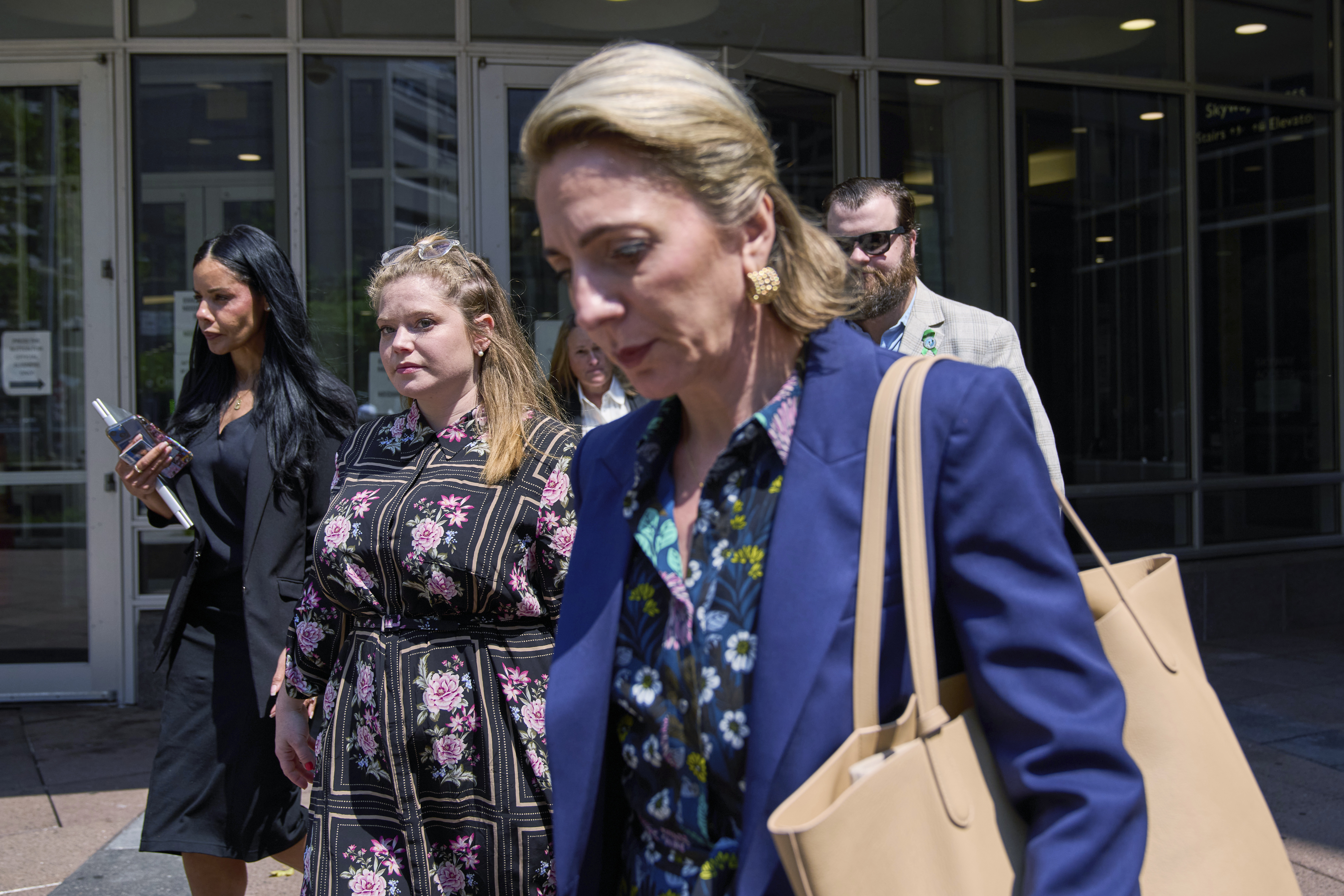 Colin Hortman, behind, son of Melissa and Mark Hortman, and his wife Alina Bachman Hortman, second from left, leave after attending the initial state court appearance for Vance Boelter on Monday in Minneapolis.
