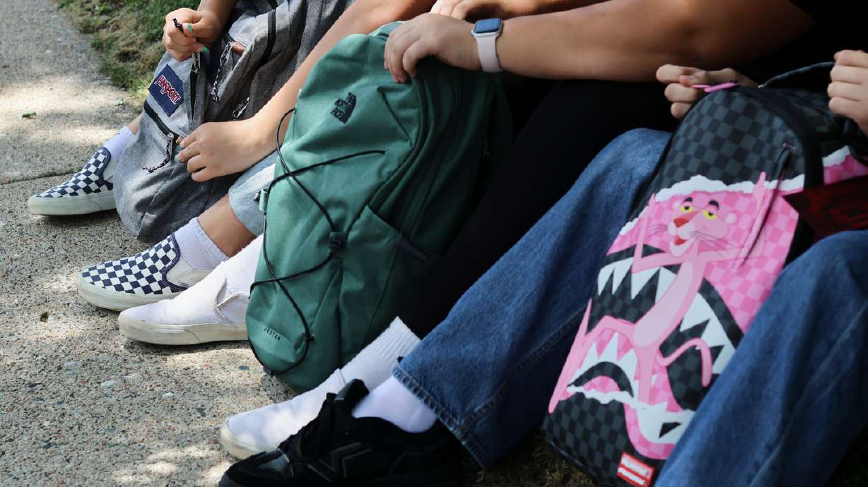Middle school students Claire Knoth and Brockton Lozano and high school student Zoie Knoth share what is in their backpacks Friday, in Flagstaff, Ariz.