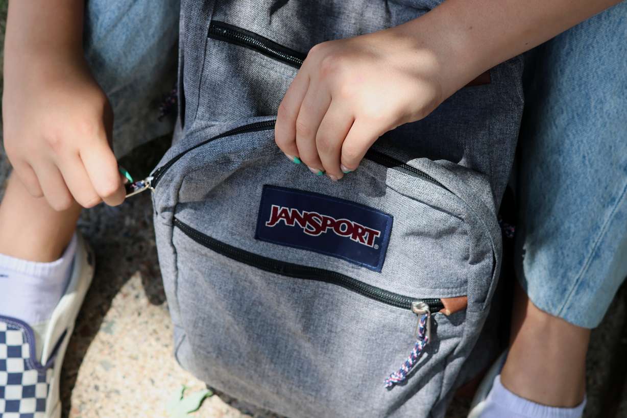 Middle school student Claire Knoth, 13, zips up her backpack after packing it with school supplies Friday in Flagstaff, Ariz.