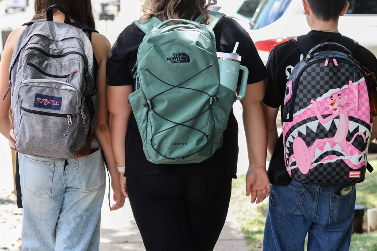 Middle school students Claire Knoth and Brockton Lozano and high school student Zoie Knoth walk with their backpacks Friday in Flagstaff, Ariz.