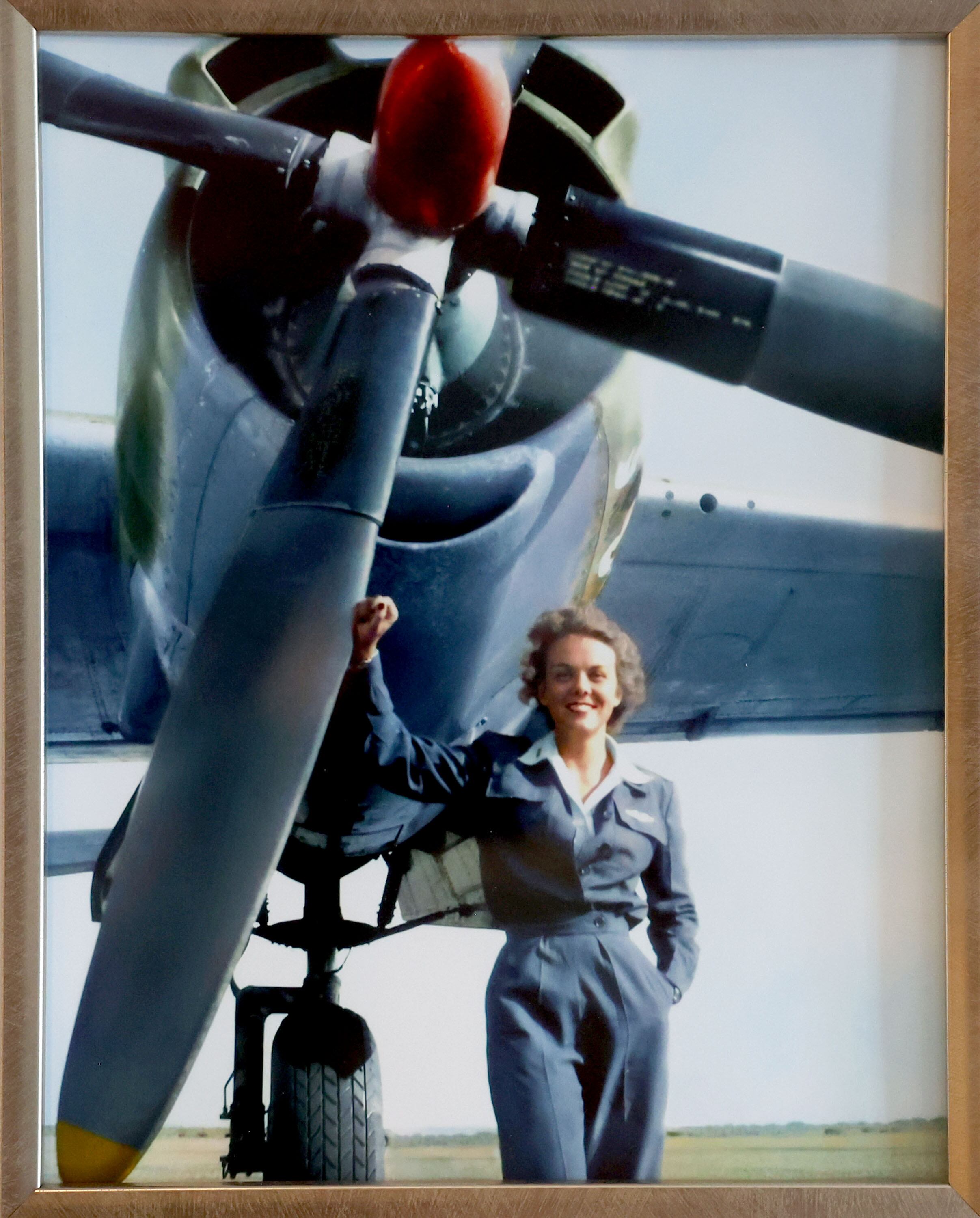 A photograph of Nell “Mickey” Stevenson Bright from 1944 hangs in the living room of her home in Salt Lake City on July 15. Bright is standing next to the B-26 that she flew in World War II.