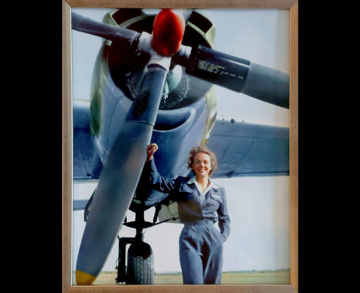 A photograph of Nell “Mickey” Stevenson Bright from 1944 hangs in the living room of her home in Salt Lake City on July 15. Bright is standing next to the B-26 that she flew in World War II.