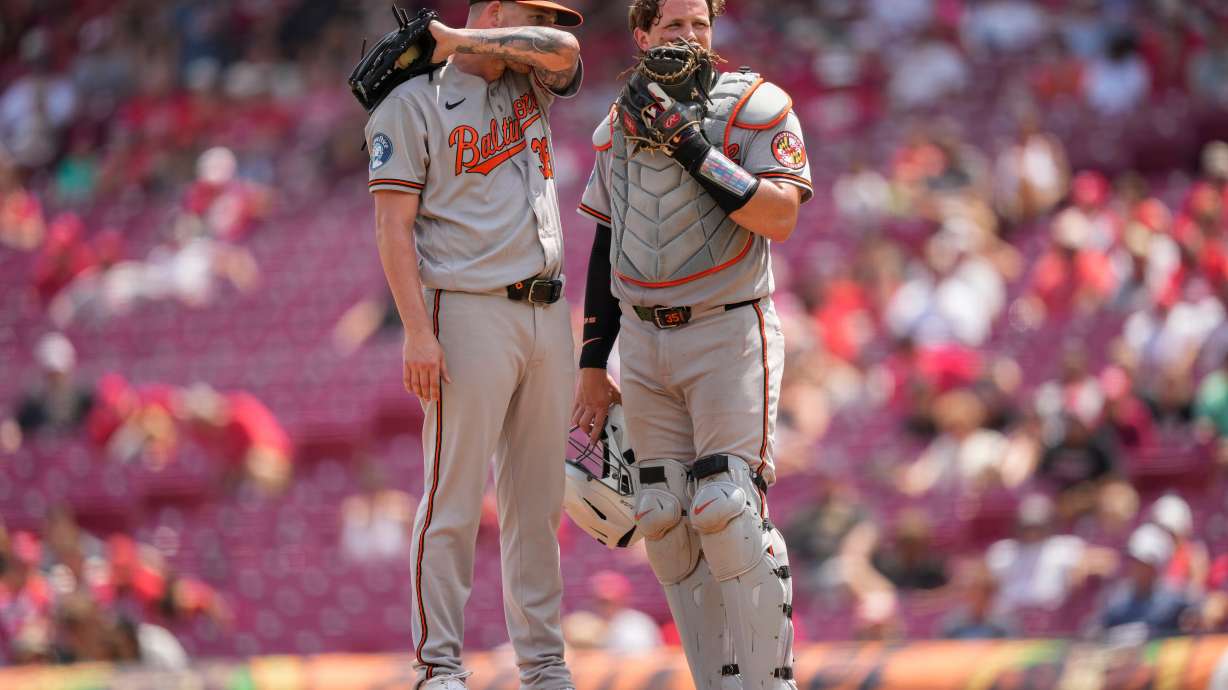 Baltimore Orioles pitcher Kyle Bradish, left, and catcher Adley Rutschman, right, talk on the mound during the eighth inning of a baseball game against the Cincinnati Reds in Cincinnati, Sunday, July 5, 2026.