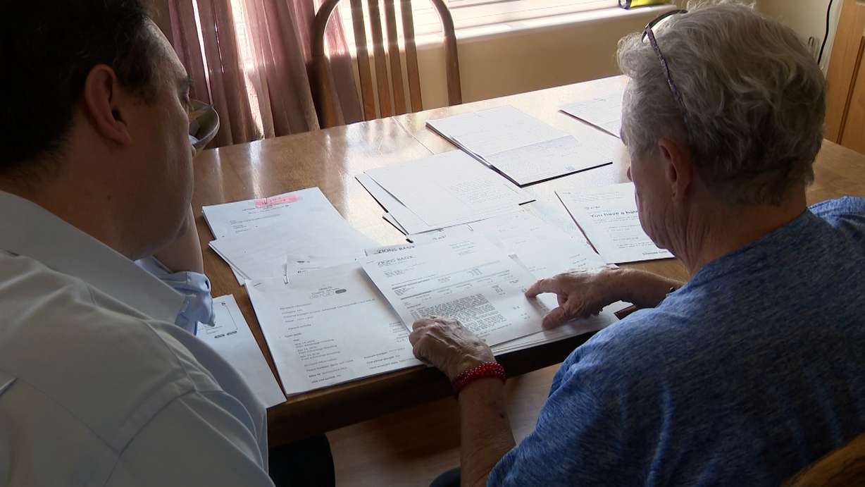 Marilyn Newbold shows KSL's Matt Gephardt the documentation that she paid for three months of service after AT&T threatened to send her to collections.