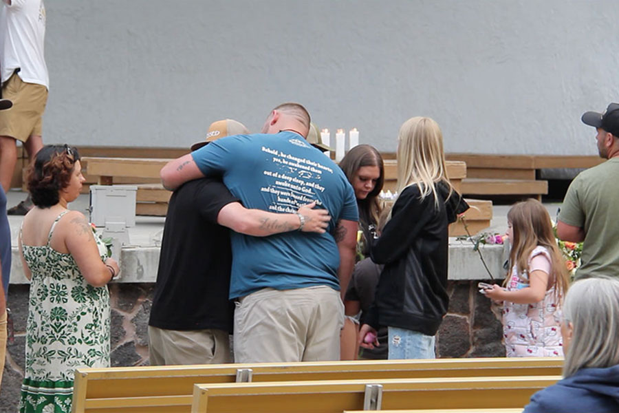 Two men embrace while waiting in line at the memorial for the victims of the In-N-Out shooting at Twin Falls City Park in Idaho, Tuesday. Three people were killed, including the gunman, and seven more were injured in the shooting.