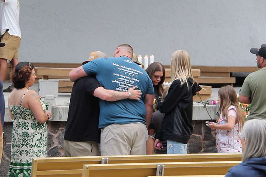 Two men embrace while waiting in line at the memorial for the victims of the In-N-Out shooting at Twin Falls City Park in Idaho, Tuesday. Three people were killed, including the gunman, and seven more were injured in the shooting.