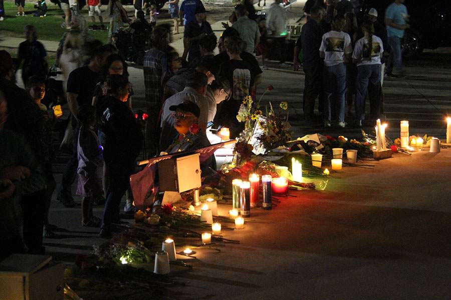 People continue to wait to see the memorial for the victims of the In-N-Out shooting as it gets dark at the Twin Falls City Park in Idaho, Tuesday. Many religious leaders also attended the vigil.