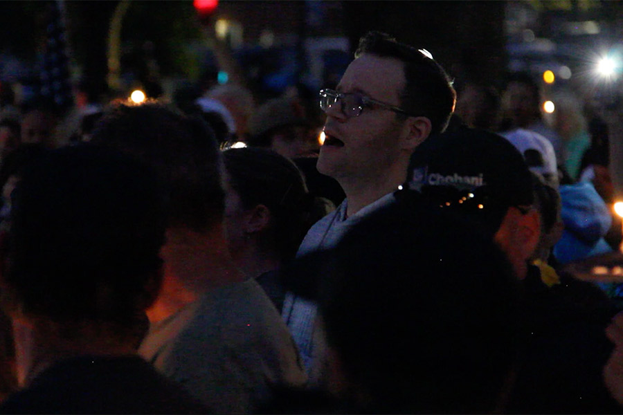 Joseph Bosteder leads the crowd in "Amazing Grace" at the vigil for the victims of the In-N-Out shooting at the Twin Falls City Park in Idaho, Tuesday. Bosteder spoke with organizers about the singing before it occurred.