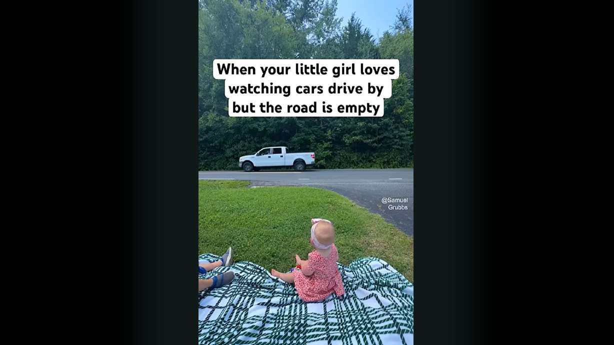 A father drives in the roadway in front of his daughter to make her happy.