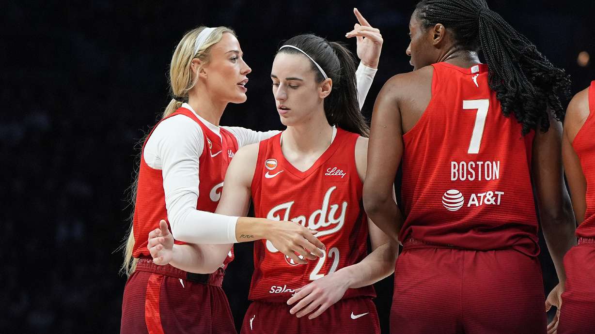 Indiana Fever guards Sophie Cunningham, left, Caitlin Clark (22) and center Aliyah Boston (7) stand on the court during the first half of a WNBA basketball game against the Minnesota Lynx, Sunday, Aug. 2, 2026, in Minneapolis.