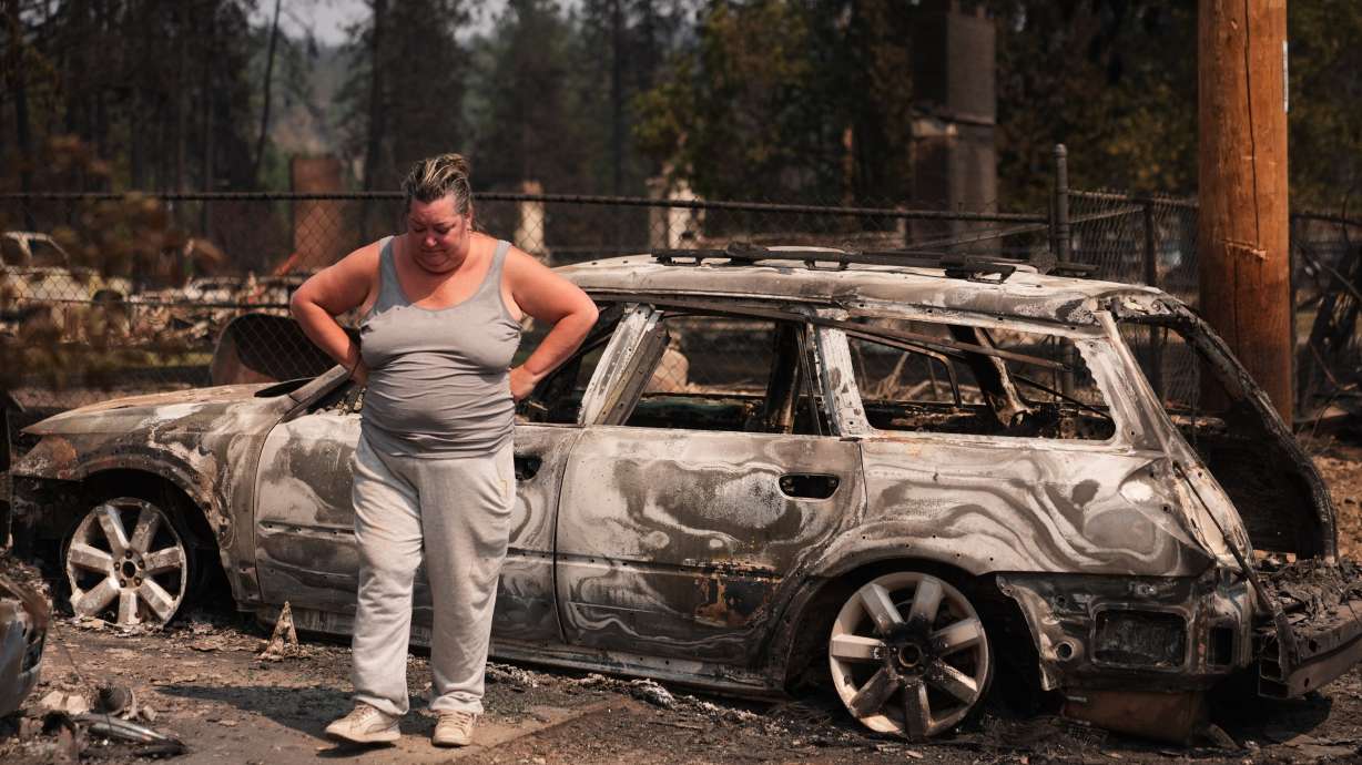 Michelle Angstrom reacts to her burned down home and property after a wildfire hit the northwest part of Spokane, Wash., Tuesday.