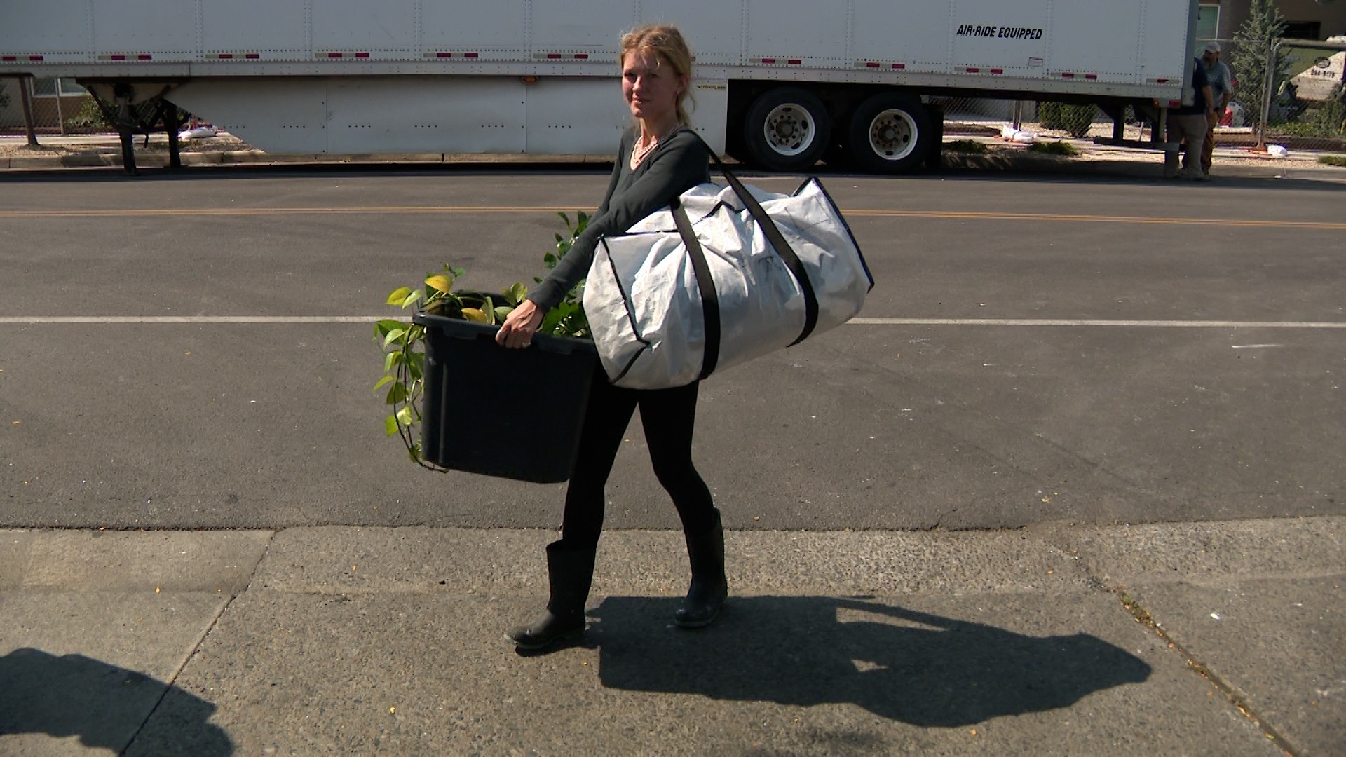 A woman carries items out of North Union Apartments on Wednesday.