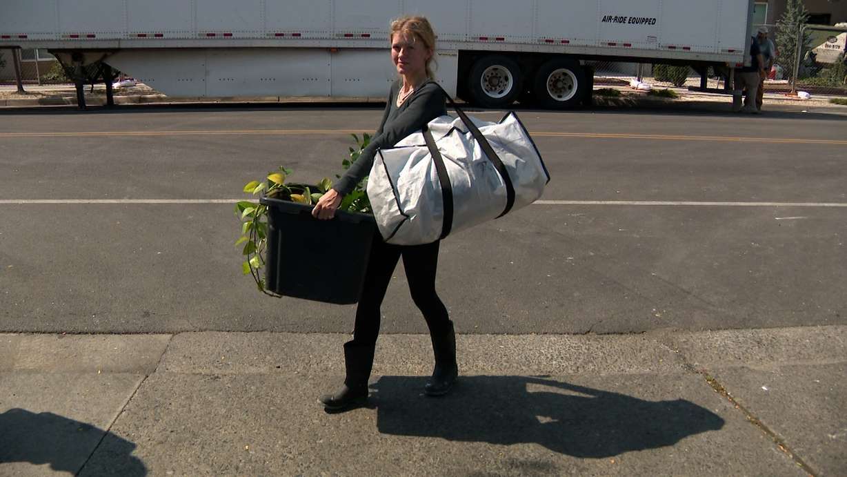 A woman carries items out of North Union Apartments on Wednesday.