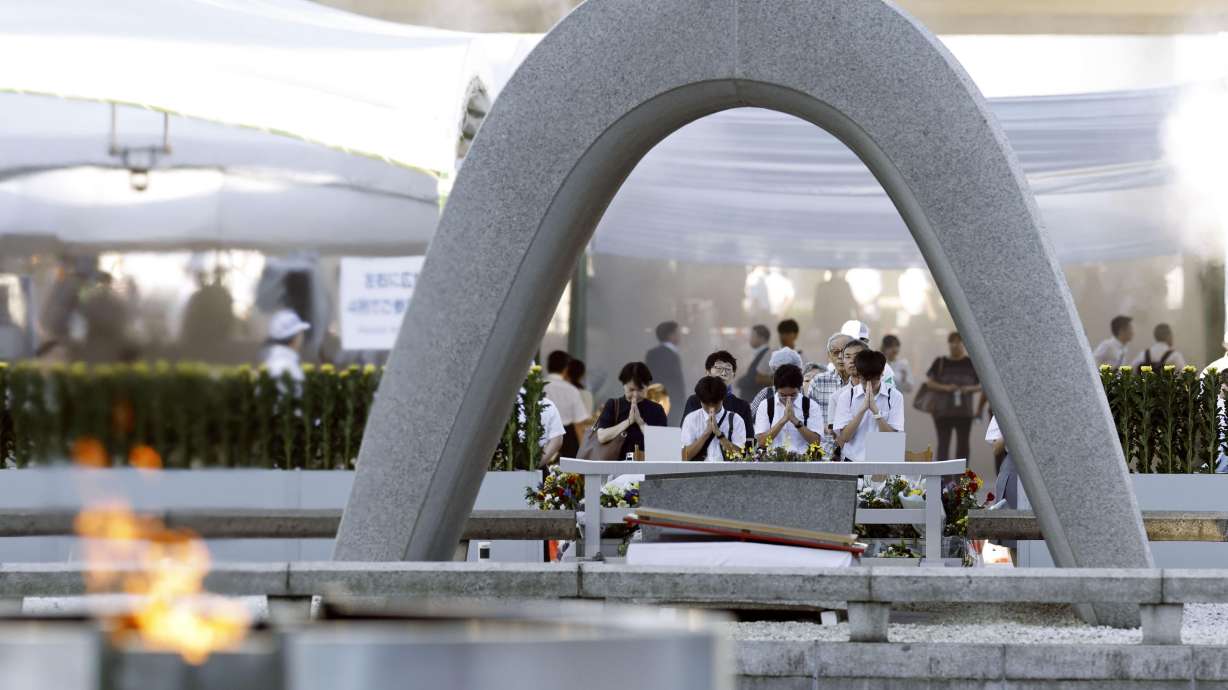 Visitors pray in front of the cenotaph dedicated to the victims of the atomic bombing ahead of a ceremony to mark the anniversary of the bombing at the Hiroshima Peace Memorial Park in Hiroshima, Japan, Thursday. The city's mayor also called for an end to possessing nuclear weapons as a method of deterrence.
