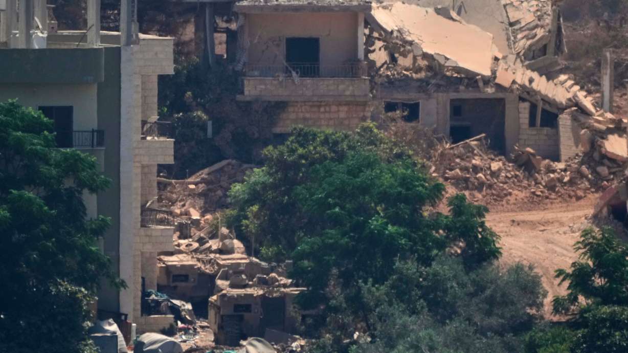 Israeli military vehicles are seen stationed among homes in the village of Zawtar al-Sharqiyah, occupied by Israeli forces, is seen from the southern village of Zawtar al-Gharbieh, Lebanon, Wednesday. Two Israeli soldiers died in an explosion in southern Lebanon, the first since the ceasefire began.