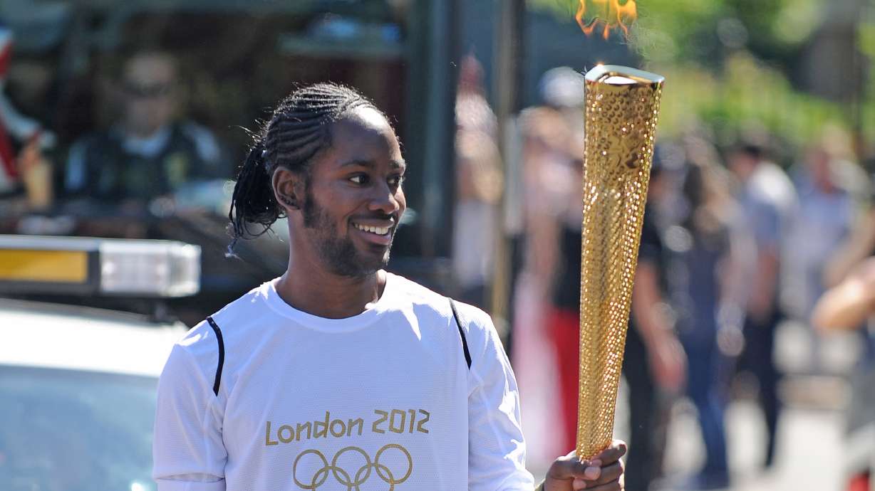 Torchbearer Jason Arday carries the Olympic Flame on the Torch Relay leg between Sutton and Merton, in London, July 23, 2012. Arday resigned on Thursday from the University of Cambridge as the school investigates allegations of plagiarism.