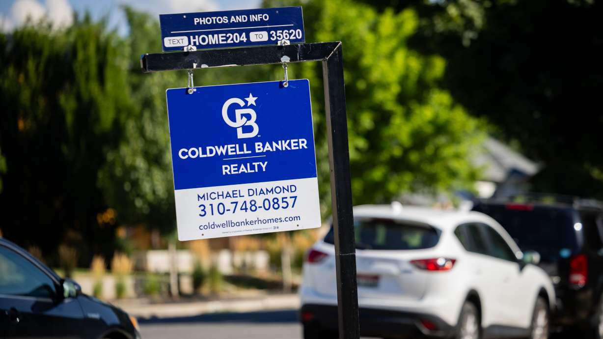 A realty sign in the 9th and 9th neighborhood in Salt Lake City on July 23. It actually takes slightly less income to buy a median-priced home in the United States than a year ago, a new analysis shows.
