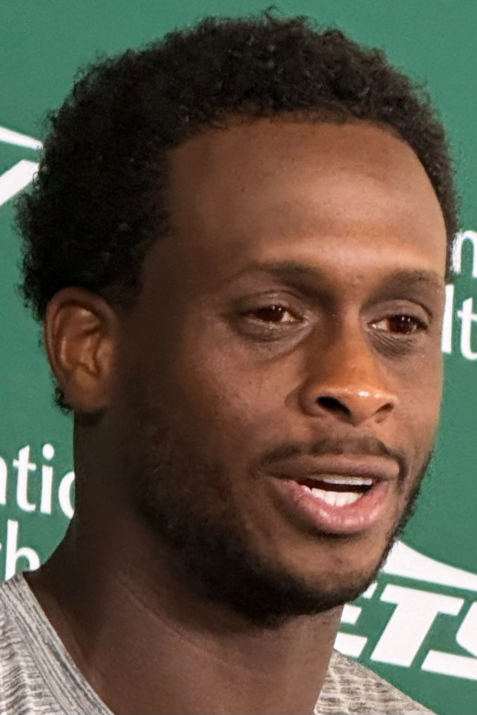 New York Jets quarterback Geno Smith, wearing red contact lenses, speaks to reporters after practice at the team’s training facility in Florham Park, N.J., on Thursday, Aug. 6, 2026. 