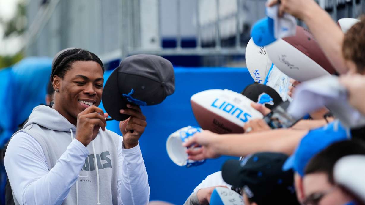 Detroit Lions running back Jahmyr Gibbs signs autographs for fans after practice at the NFL football team's training camp, in Allen Park, Mich., Sunday, Aug. 2, 2026.
