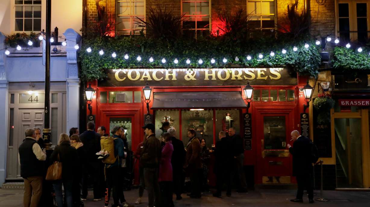 People stand drinking outside Coach & Horses on Saint Patrick's Day in the Covent Garden district of central London, a popular tourist area, March 17, 2020. A proposal to limit "vertical drinking" has hit a snag in the Westminster City Council.