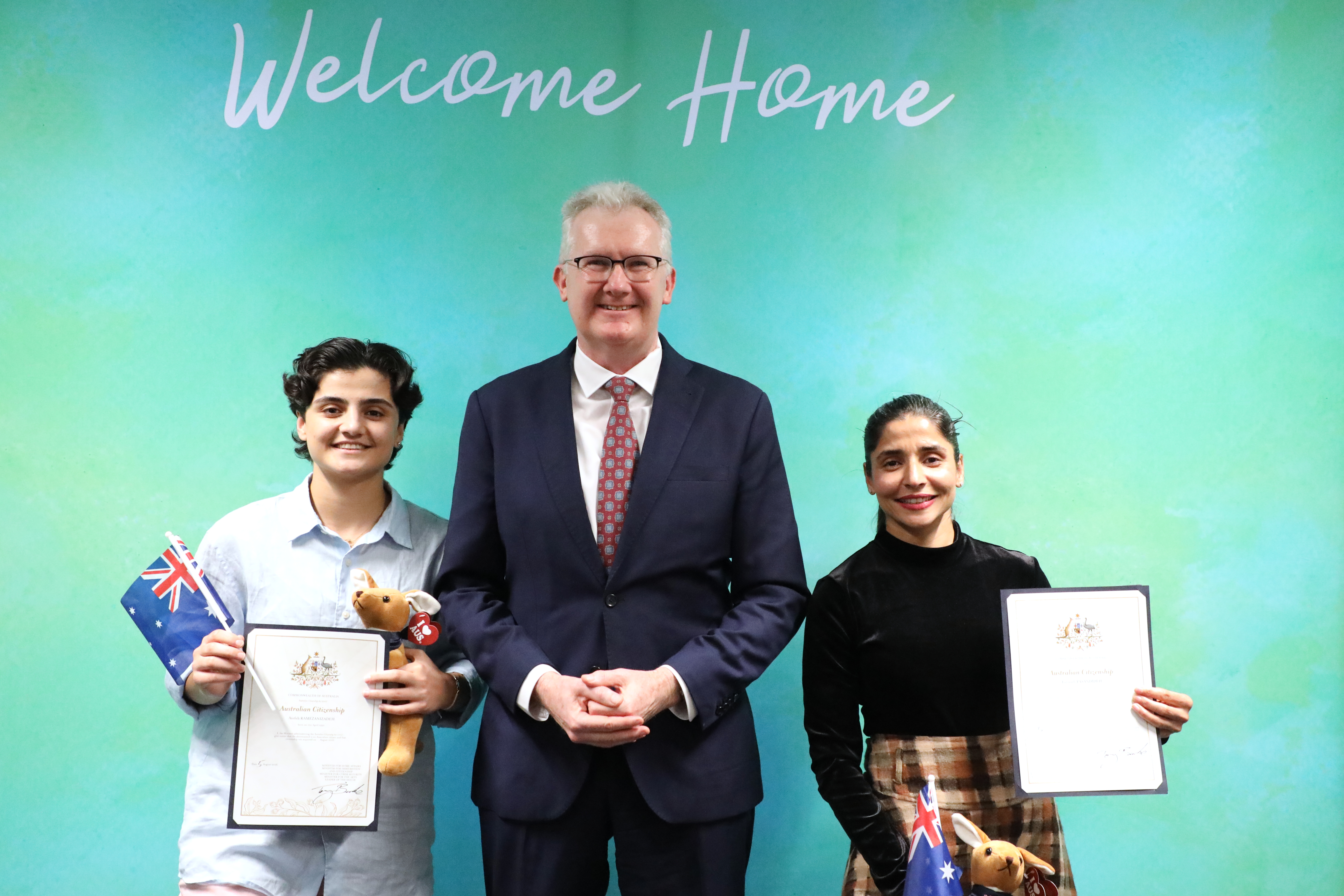 Fatemeh Pasandideh, left, and Atefeh Ramezanisadeh, former members of the Iranian women’s soccer team, stand with Australia's Minister for Home Affairs, Tony Burke, after receiving their citizenship in Brisbane, Australia, Wednesday, Aug. 5, 2026. 
