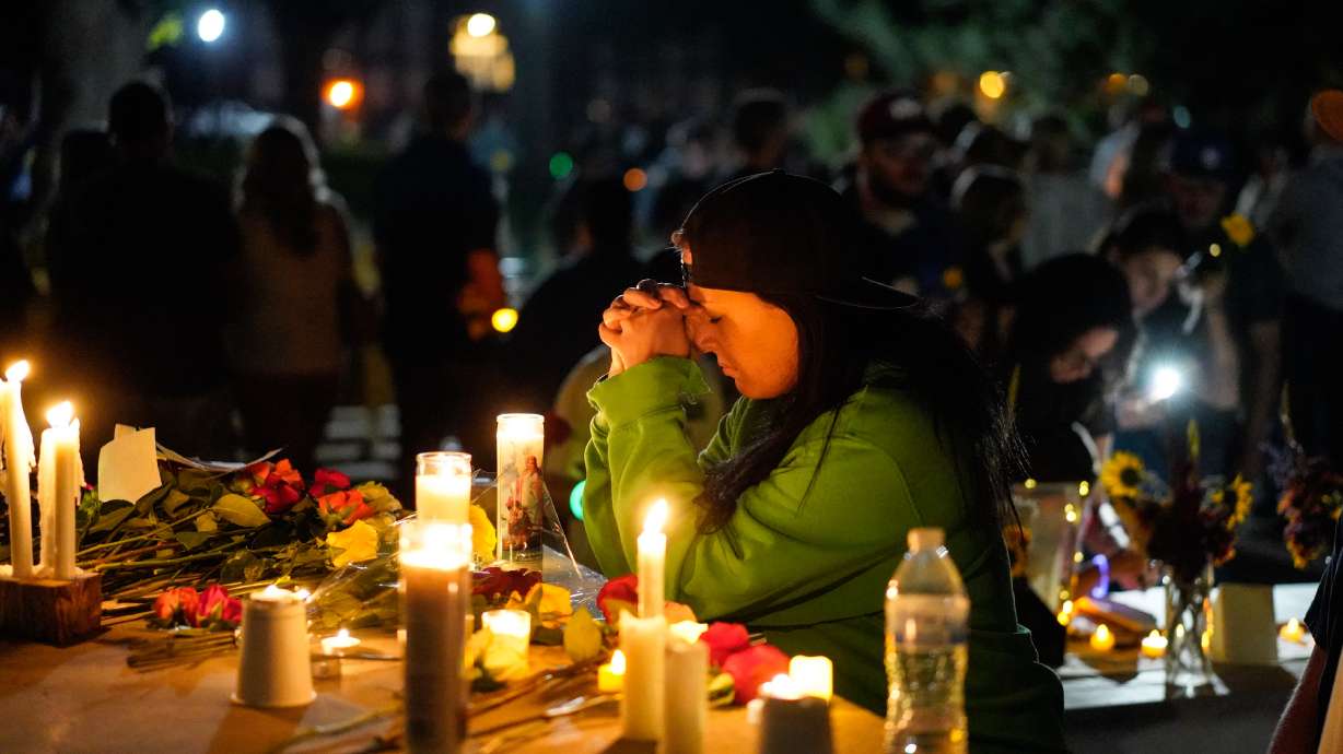 A woman prays during a candlelight vigil Tuesday, in Twin Falls, Idaho, to honor the victims of a recent shooting at a local In-N-Out Burger. New video released on Friday showed the gunman killing one of the victims through a drive-up window.