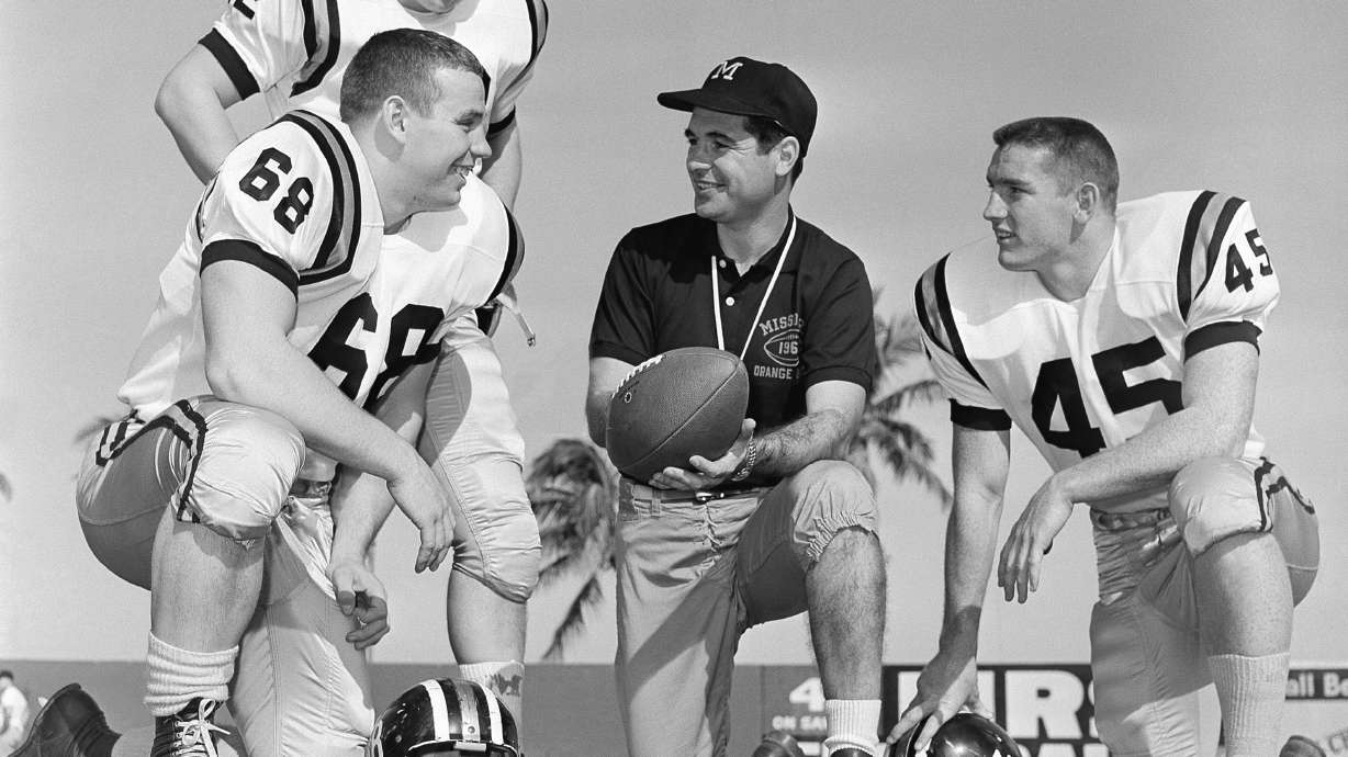 FILE - Missouri head coach Dan Devine, center, meets with three of his girders, Paul Henley (68), guard; Ron Tayler (12), quarterback; and Donnie Smith (45), halfback, in Miami on Dec. 27, 1960.
