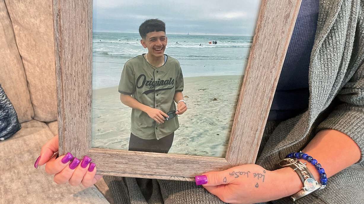 Leslie Caballero, the mother of Mason Caballero, killed in a shooting in Ogden last year, struggles forward with a message to parents — be involved in your kids' lives. She's pictured holding a photo of Mason at her home in Taylor on July 30, 2026.