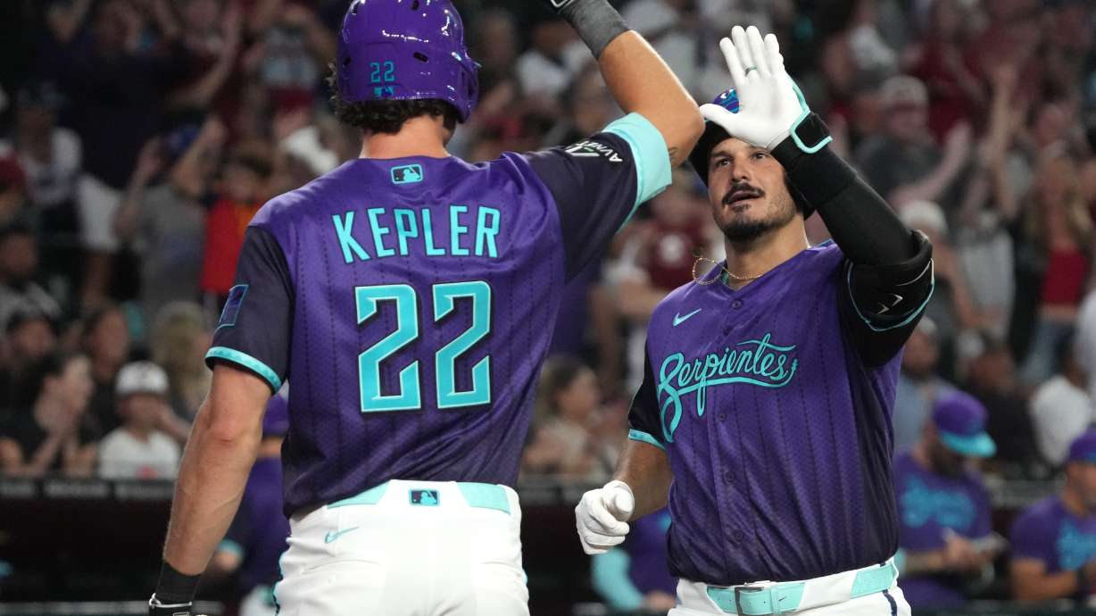 Arizona Diamondbacks' Nolan Arenado, right, celebrates with Max Kepler (22) after hitting a solo home run against the Los Angeles Dodgers in the second inning of a baseball game, Friday, Aug 7, 2026, in Phoenix.