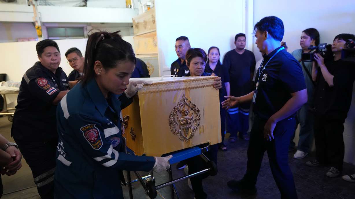 A coffin containing the body of a victim of Friday's shooting at the Debsirin Nonthaburi School, is brought in a stretcher at a police hospital in Bangkok, Thailand, Saturday. A 12-year-old girl died from her injuries to bring the death toll to eight.