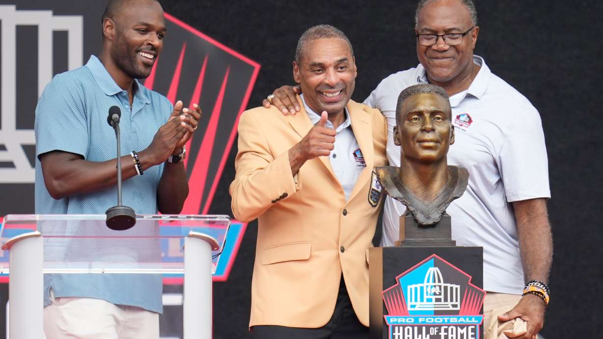 Former NFL player Roger Craig, center, unveils his bust with son, Roderick Craig, left, and Jamie Williams during the Pro Football Hall of Fame induction ceremony at the Pro Football Hall of Fame, in Canton, Ohio, Saturday, Aug. 8, 2026.