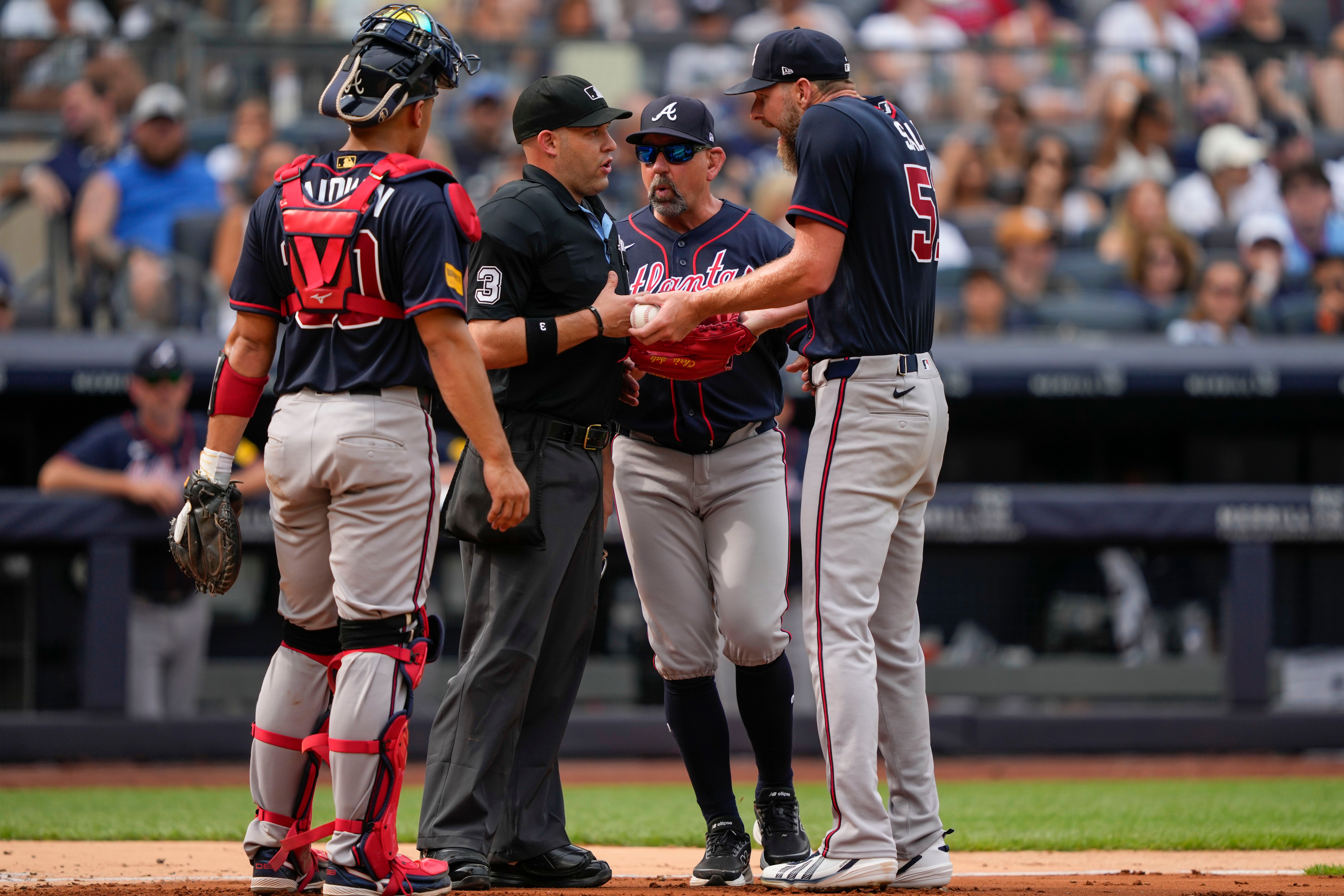 Atlanta Braves pitcher Chris Sale, right, argues with home plate umpire Dan Merzel, second left, during the fifth inning of a baseball game against the New York Yankees, Saturday, Aug. 8, 2026, in New York. 