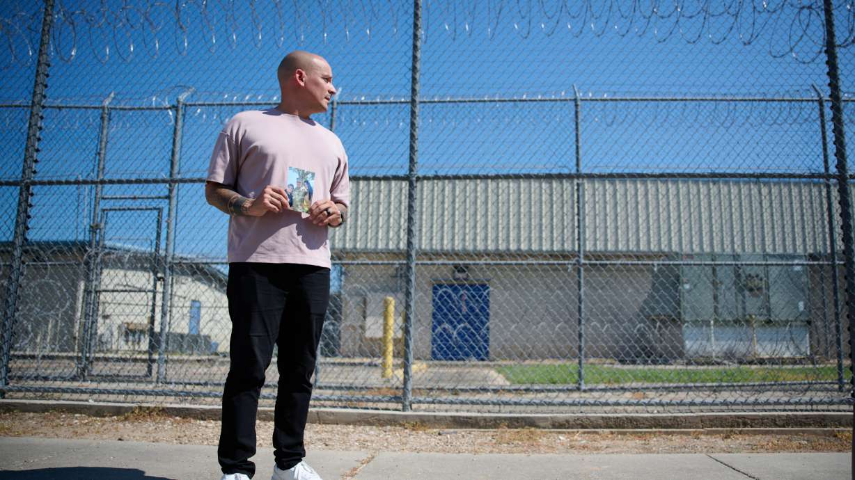 Army Staff Sgt. Alexis Jaramillo poses with a photo of his wife, Maisa Lopes Eliaser, a Brazilian national who is being detained by ICE, before visiting her at the South Louisiana ICE Processing Center in Basile, La., Aug. 2.