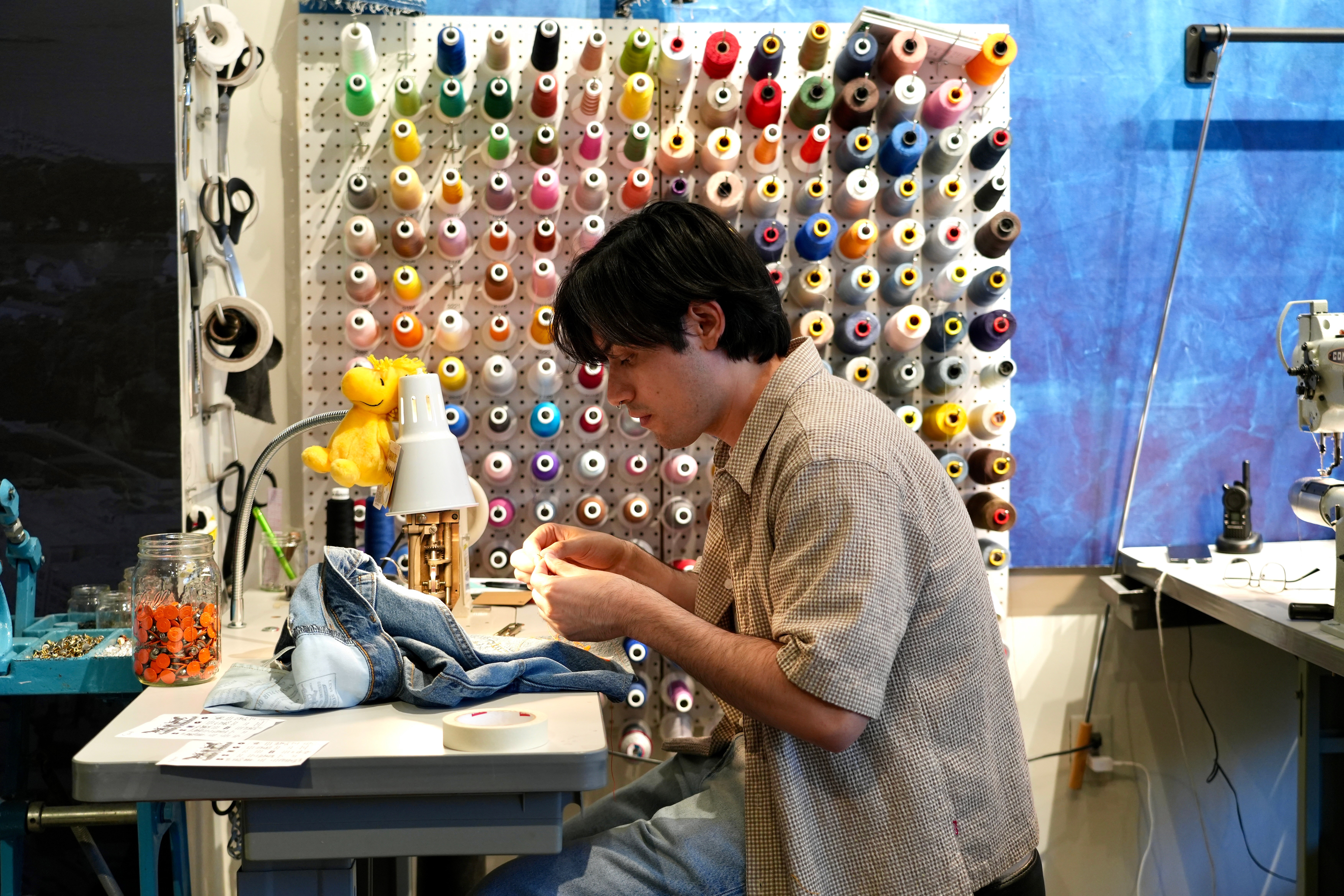 Genaro Ruiz sews clothing during a clothing repair workshop at a Levi's retail store in downtown San Francisco on July 22.