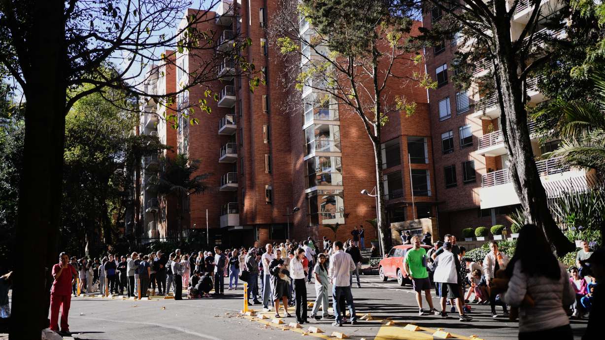 People stand outside their homes after a quake was felt in Bogota, Colombia, Monday.