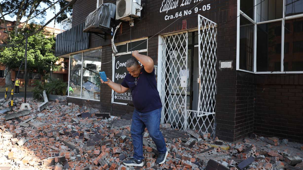 A man leaves an apartment building after an earthquake struck Cali, Colombia, Monday.