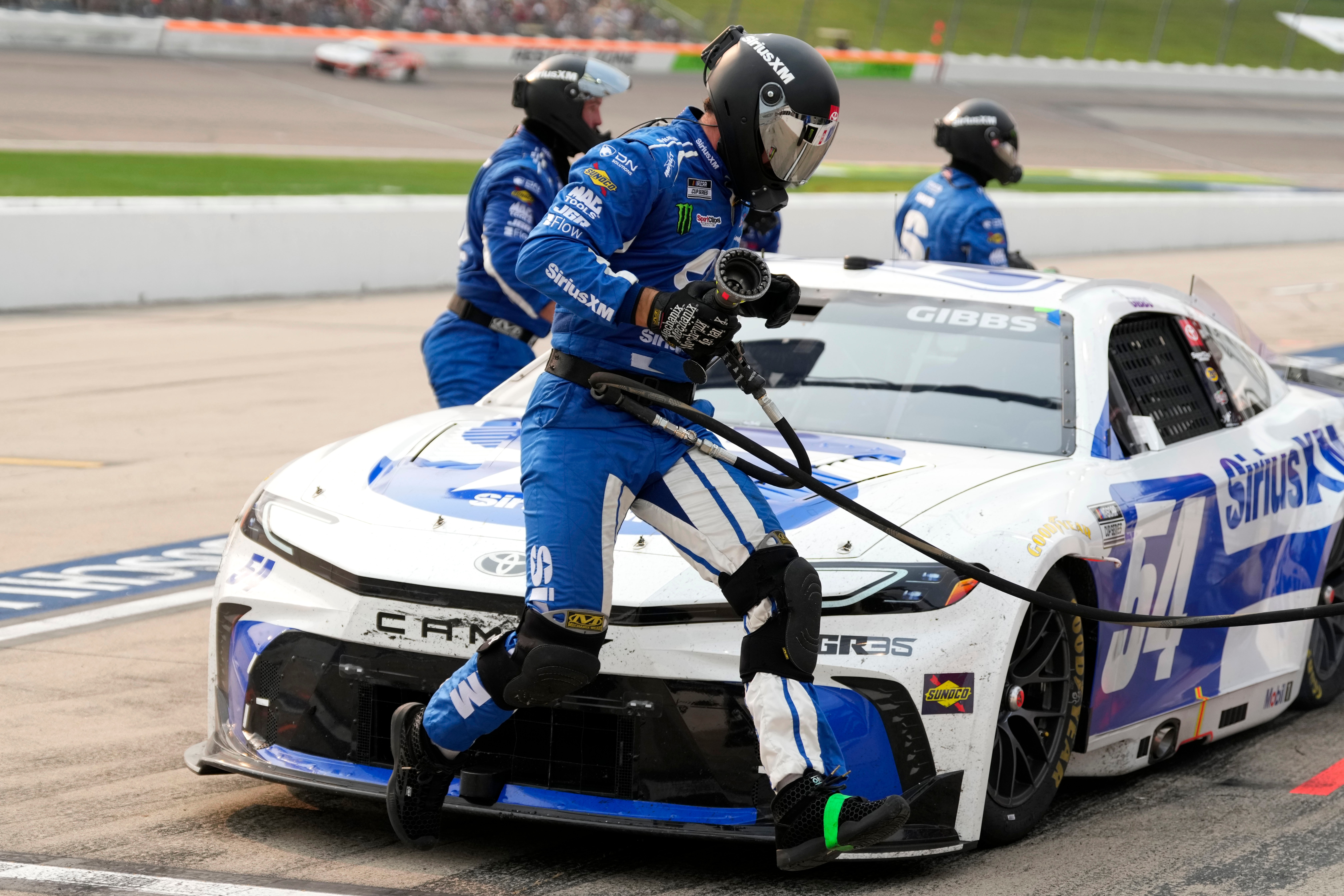 A crew member leaps in front of Ty Gibbs' car during a pit stop in a NASCAR Cup Series auto race, Sunday, Aug. 9, 2026, at Iowa Speedway in Newton, Iowa. 