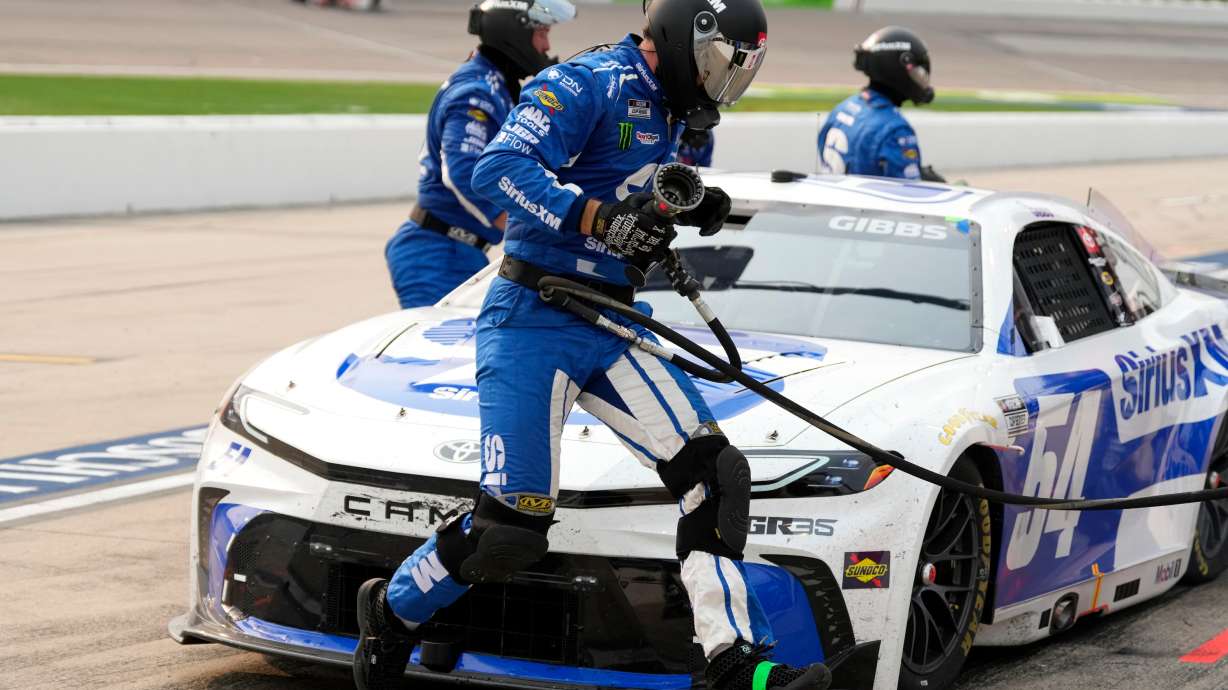 A crew member leaps in front of Ty Gibbs' car during a pit stop in a NASCAR Cup Series auto race, Sunday, Aug. 9, 2026, at Iowa Speedway in Newton, Iowa.