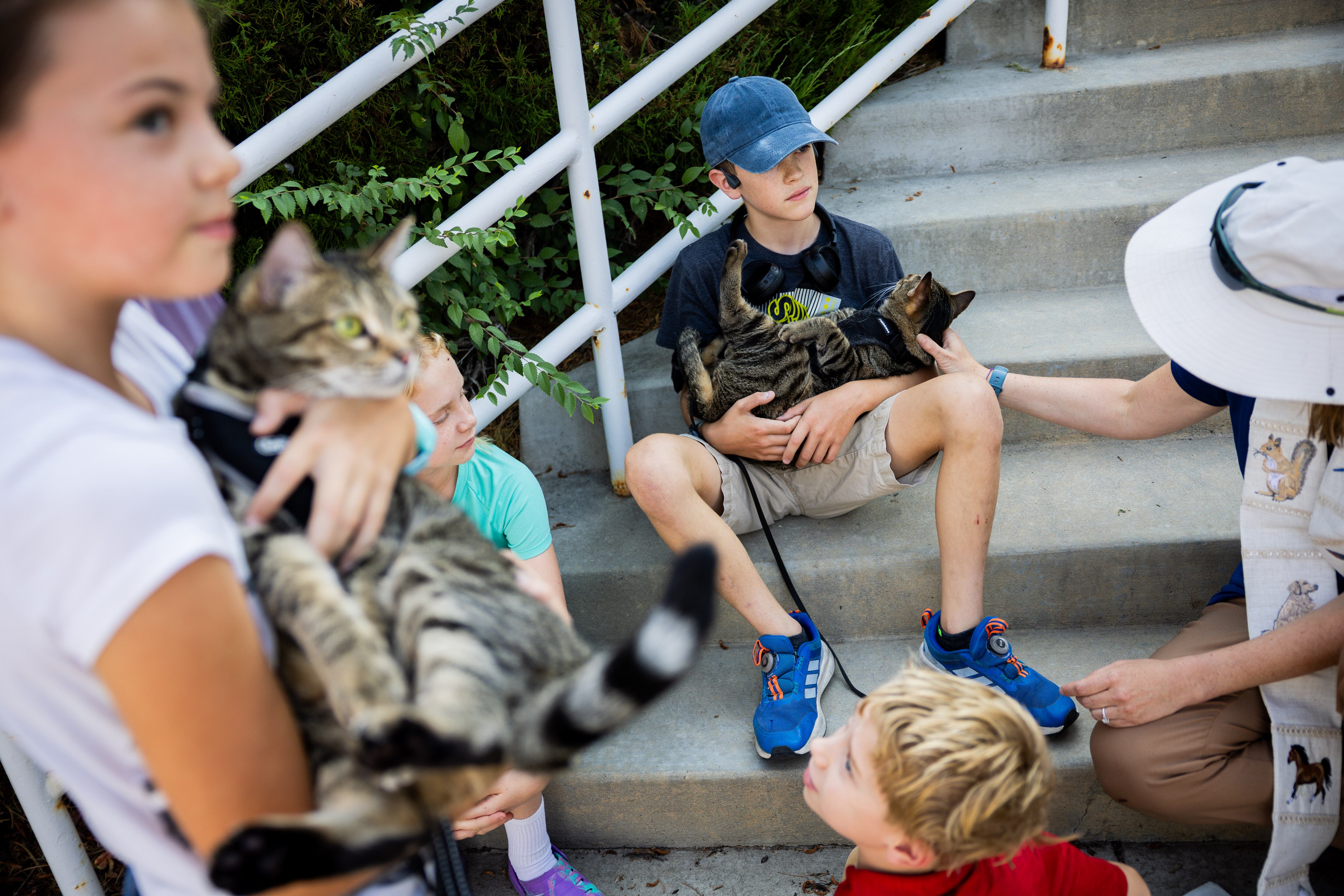 Mazie Kovach, 9, left, holds her cat Savannah as Pastor Sarah Merchant, right, blesses her brother Jackson Kovach’s, 12, center, cat Chatham during a Blessing of the Animals in conjunction with the celebration of the Hilltop United Methodist Church’s 125th anniversary at Hilltop United Methodist Church in Sandy on Saturday.