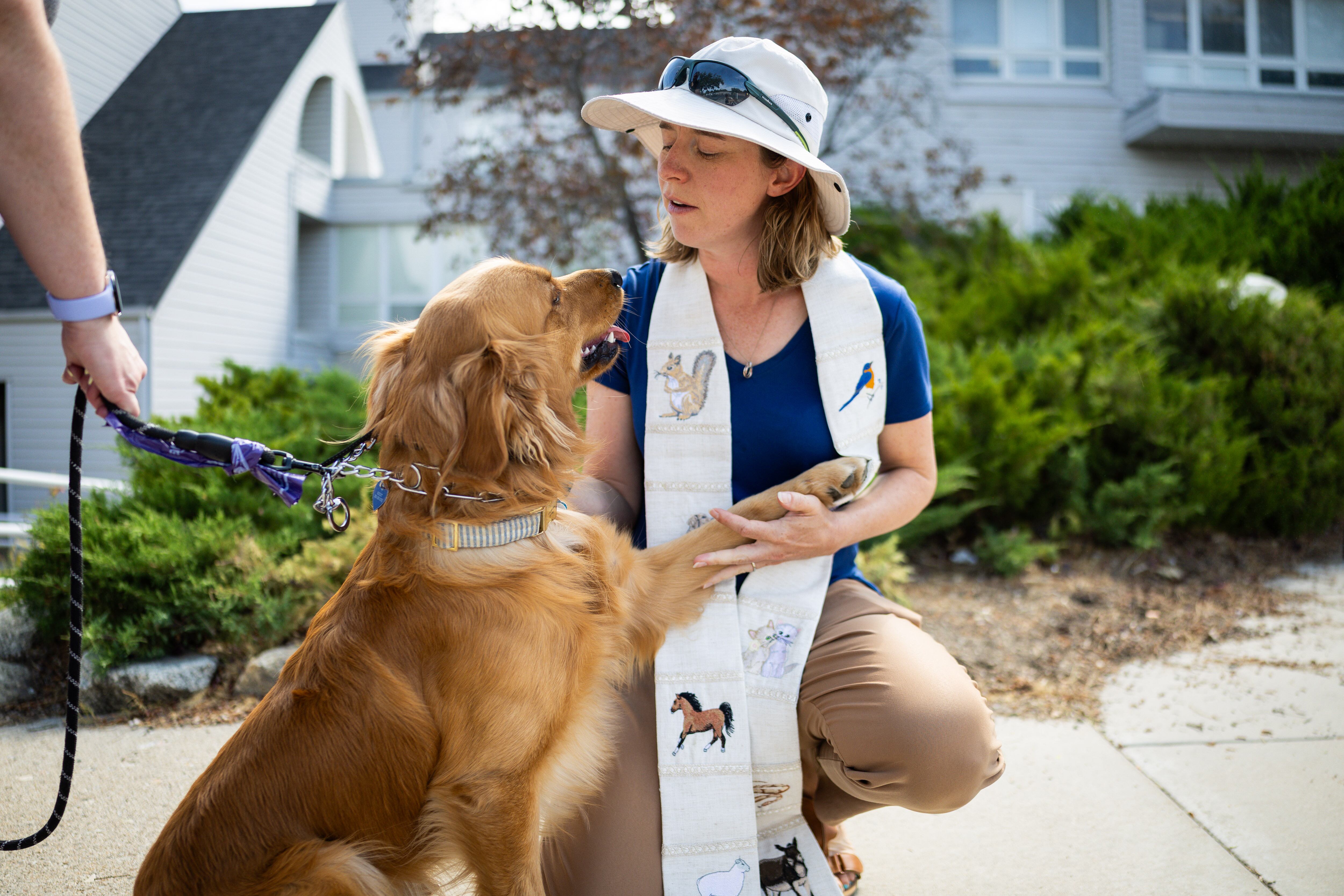 Pastor Sarah Merchant, right, blesses Biscuit, left, during a Blessing of the Animals in conjunction with the celebration of the Hilltop United Methodist Church’s 125th anniversary at Hilltop United Methodist Church in Sandy on Saturday.